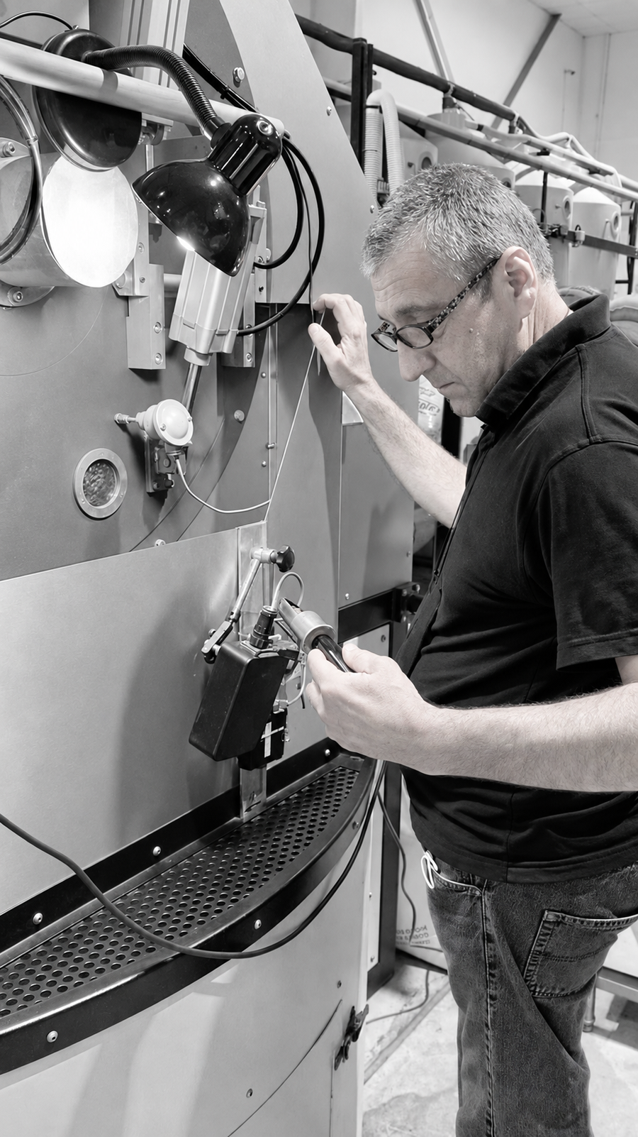 Mood Espresso’s roast master checking coffee at the roasting equipment