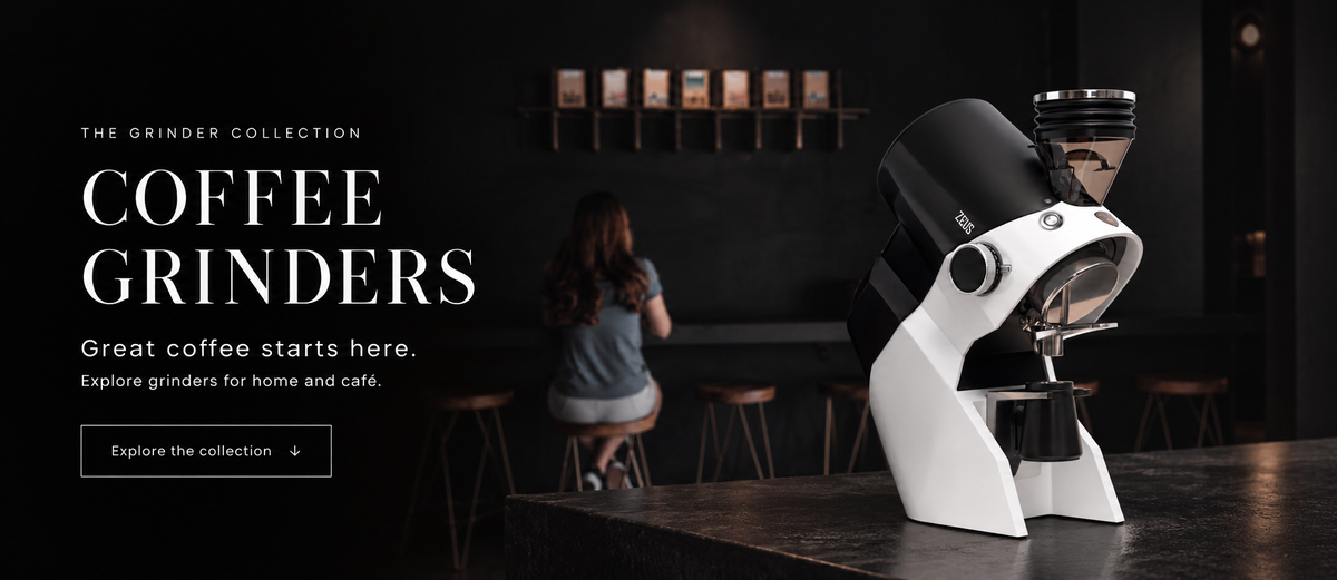 Eureka Zeus coffee grinder on a black counter in a dark café.